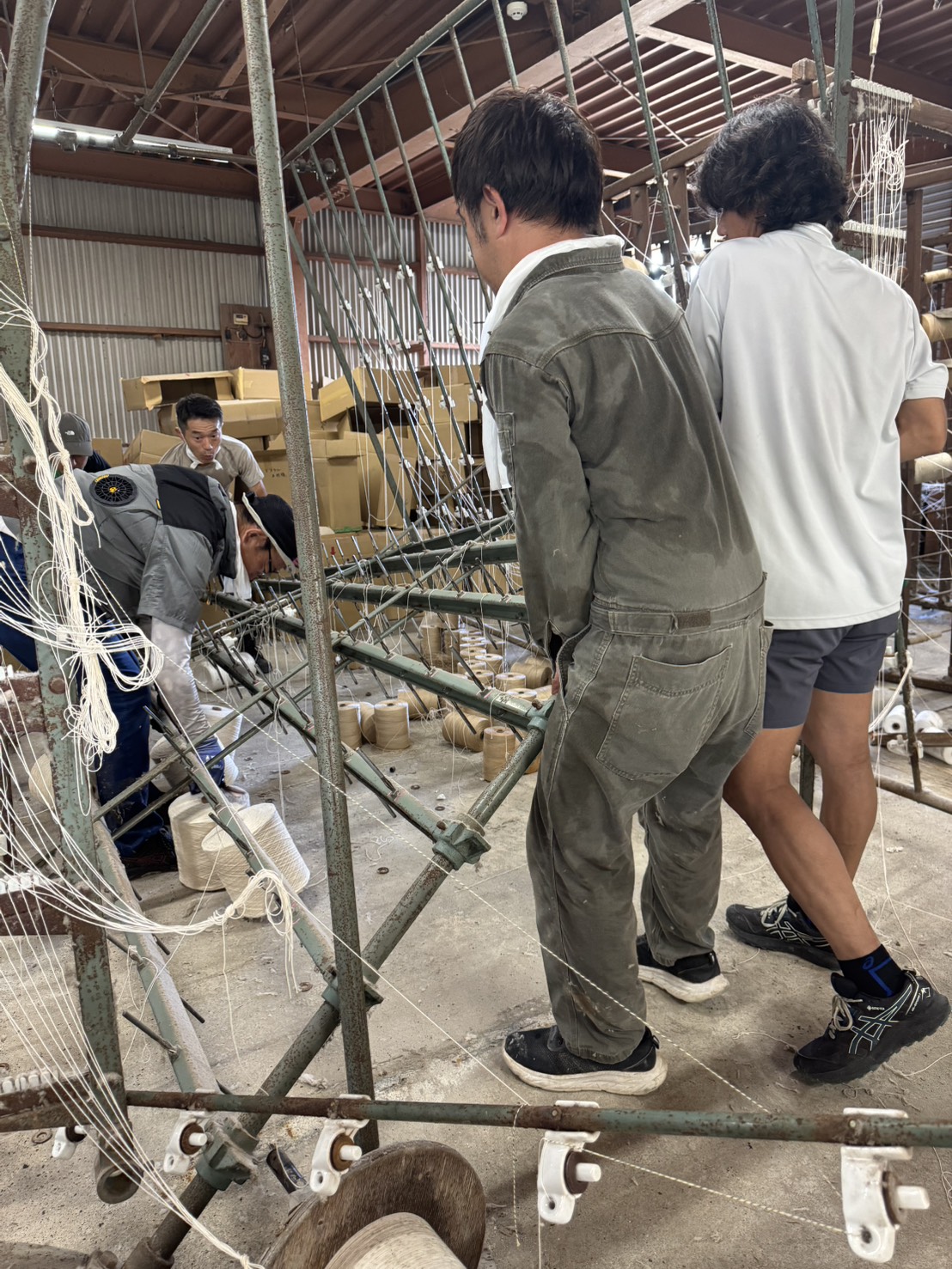 機械をかかえて、糸玉を取り出す様子